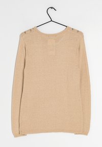 Maglione lavorato a maglia beige con scollatura rotonda, maniche lunghe e ritagli decorativi sulle spalle. Tessuto testurizzato con vestibilità rilassata.