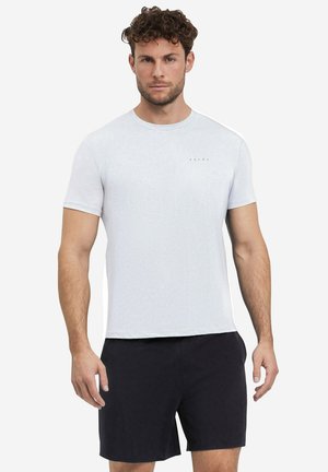 T-shirt grigio chiaro a maniche corte con colletto rotondo e logo "FALKE" sul petto, abbinato a pantaloni corti neri in tessuto liscio.