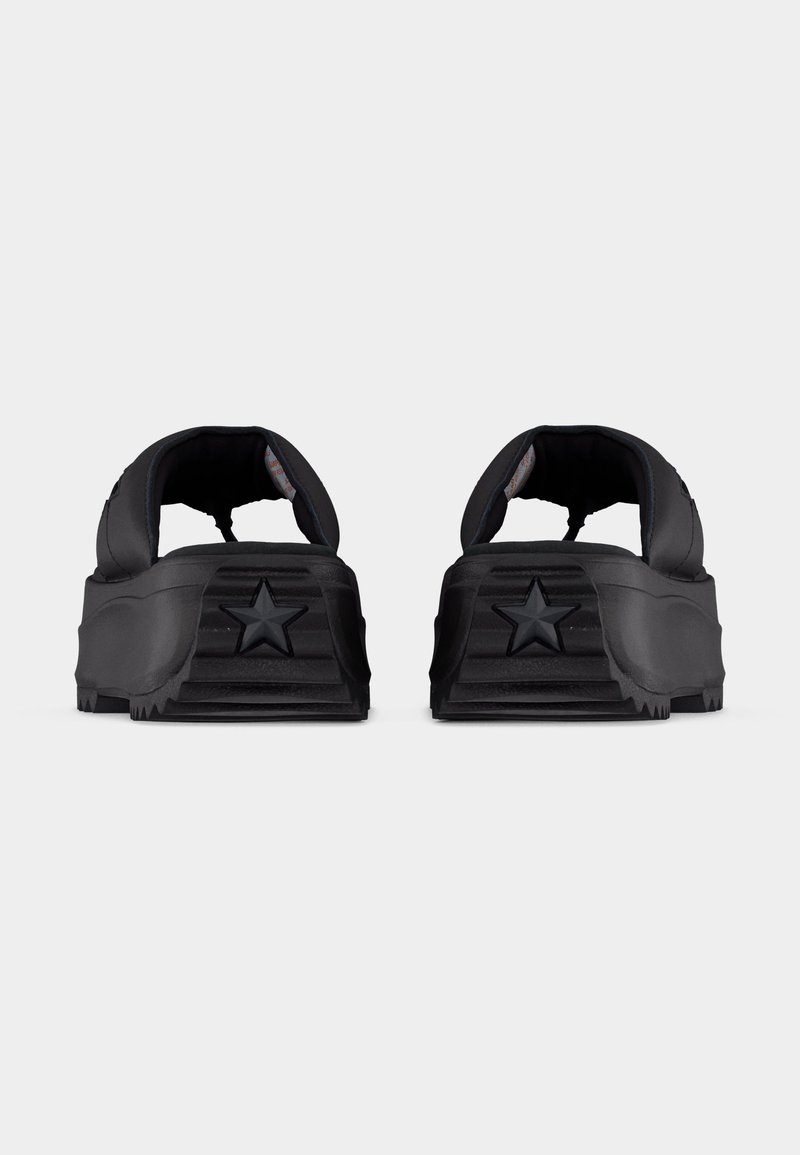 Schwarze Slip-On-Clogs mit dicken Sohlen und einem Stern, der auf der Ferse geprägt ist, von hinten auf einem schlichten weißen Hintergrund gezeigt.