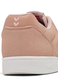 Lyserosa sneakers med en teksturert semsket overdel, hvit gummisåle, og to rosa chevron-detaljer bak. Glatt innvendig fôr.
