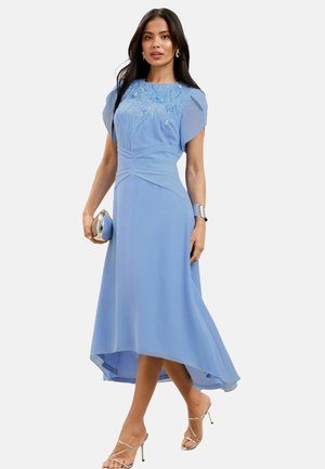 Light blue midi dress featuring short puff sleeves, embroidered floral details, a fitted waist, and a flared hem with a longer back.