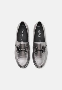 Les chaussures slip-on Gabor en cuir gris métallique présentent une finition lisse, un détail de boucle décorative et une doublure intérieure confortable.