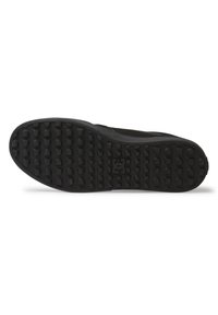 Black sneaker sole with textured, rubber material featuring multiple small circular and oval grips for traction. Simple and flat design.