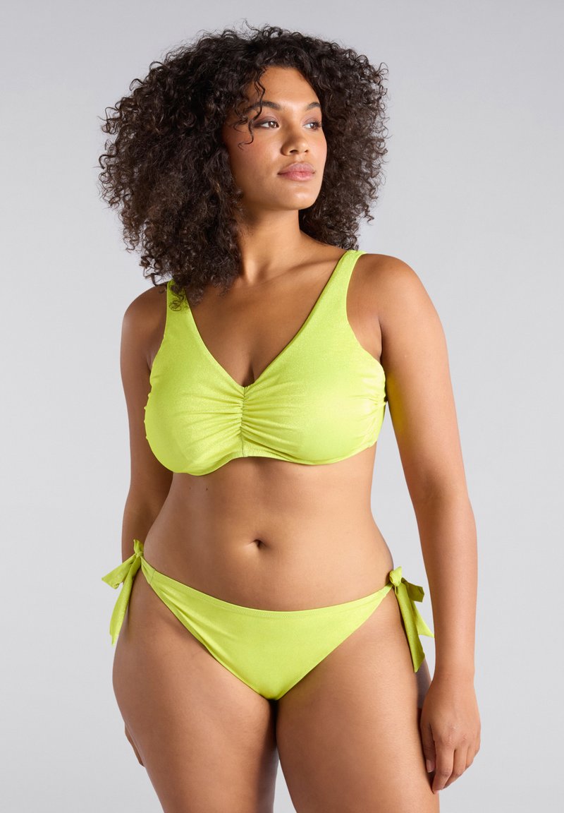 Ensemble de bikini vert citron comprenant un haut froncé avec de larges bretelles et une coupe triangulaire, associé à un bas à nouer sur les côtés. Texture lisse et extensible.
