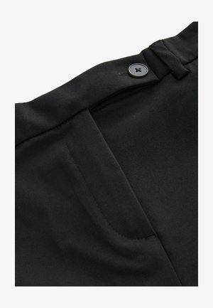 Mustad püksid, millel on sile kangas, nööbiga sulgemine ja kaldus ees taskud, mille servadel on korralik õmblus.