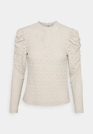 Krämfärgad långärmad topp med texturerad tyg, puffade axlar och rund halsringning. Intrikat öppet stickat mönster över hela.