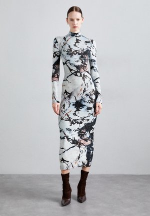 Form-fitting, long-sleeve dress in a light blue and black marble print. High neckline, mid-calf length, textured fabric, paired with brown ankle boots.
