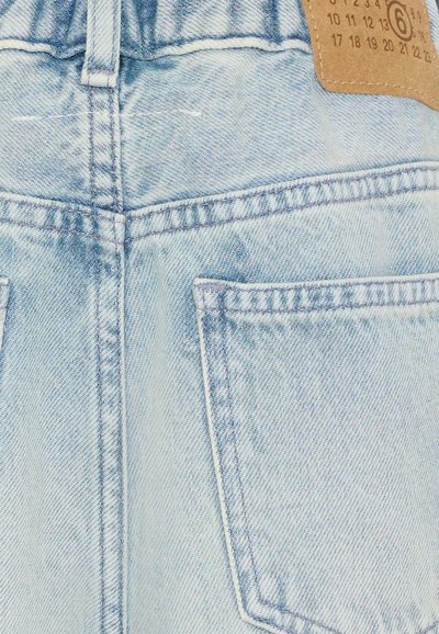 Jean en denim bleu clair vu de dos avec deux poches cousues et une patte en cuir marron ornée de chiffres sur la ceinture.