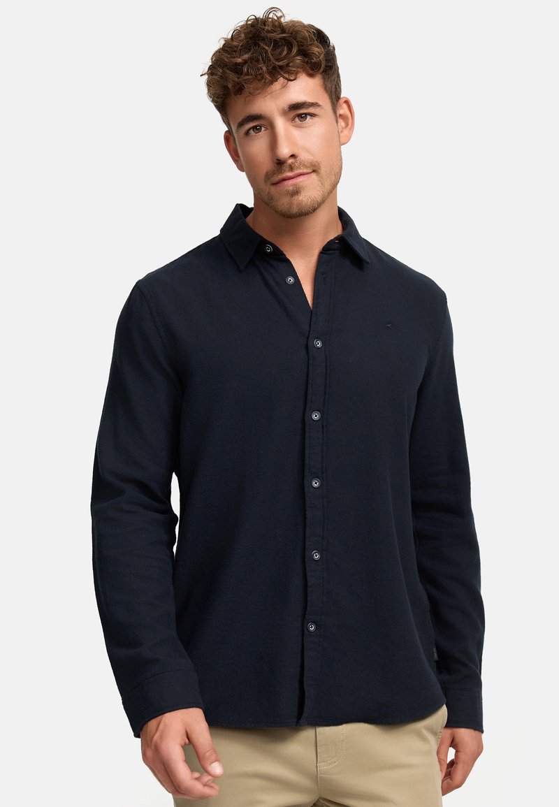 Camisa de manga larga azul marino hecha de tejido ligero, con cuello abotonado, botones en la parte delantera y una textura suave.