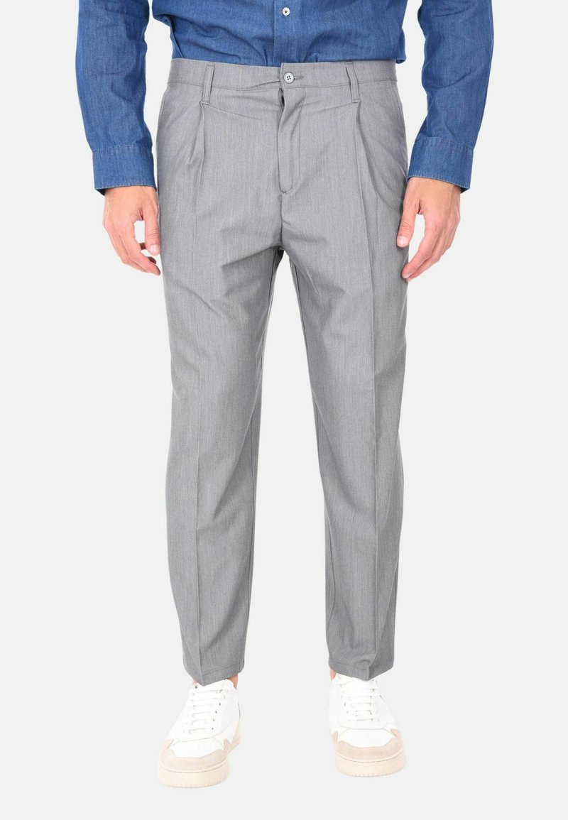 Pantaloni grigi a righe con una vestibilità comoda, caratterizzati da pieghe frontali e chiusura con bottone, abbinati a sneakers bianche. Tessuto misto cotone.