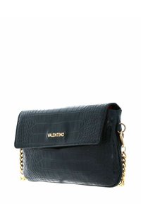 Pochette Valentino noire à motif crocodile avec logo doré sur le rabat et une chaîne dorée, sur fond blanc.