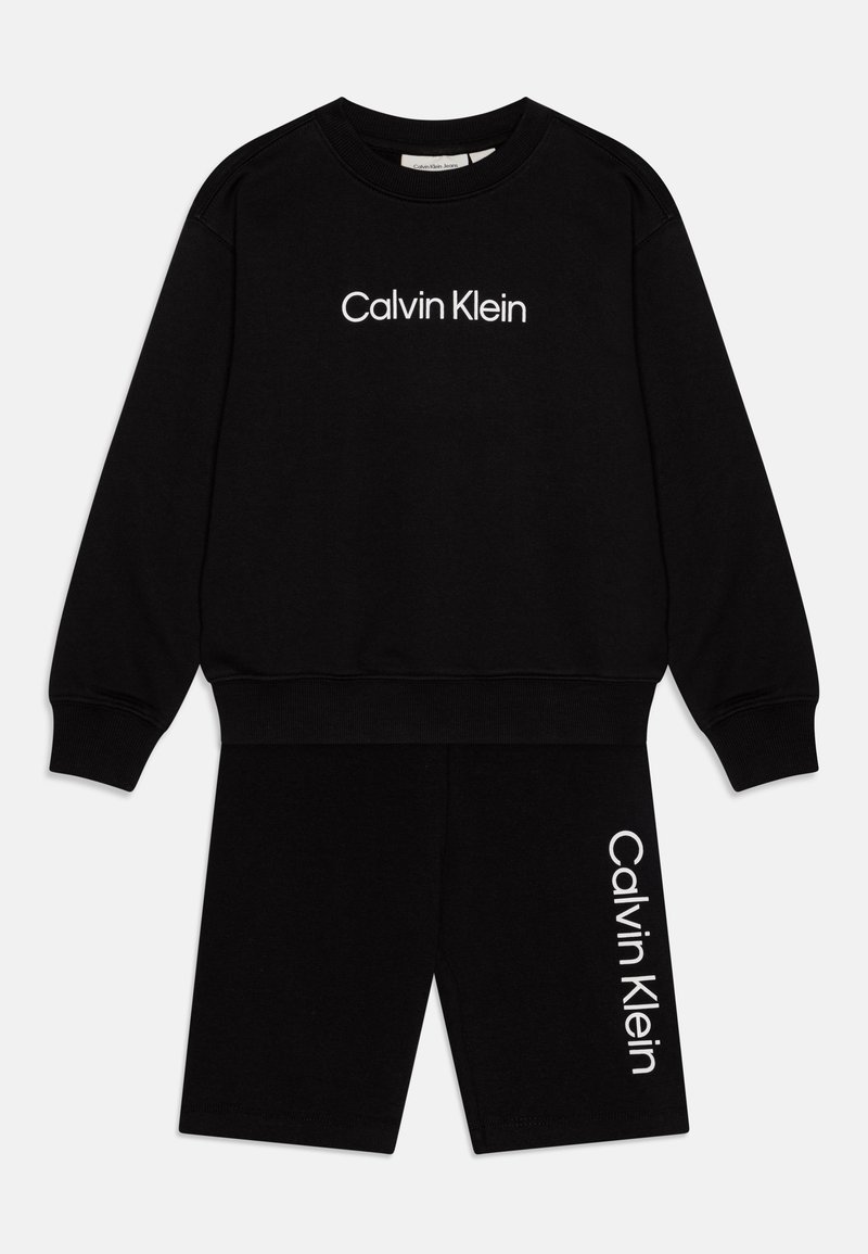 Svart bomullsloungewear-set bestående av en långärmad sweatshirt och shorts. Sweatshirten har en vit "Calvin Klein"-logga. Enkelt mönster, avslappnad passform.