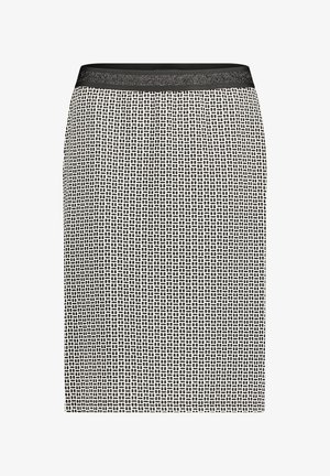 Jupe noire et blanche longueur genou avec un petit motif géométrique en tirets et une ceinture unie noire.