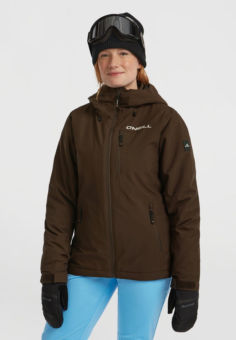 Bruine waterdichte skijas met een capuchon, voorzien van ritszakken, verstelbare manchetten en een logo op de borst. Gepaard met blauwe skibroeken.