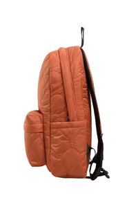 Gequilted oranje rugzak met een ronde vorm, voorzien van een voorvak en zwarte banden. Glad qua textuur, minimalistisch ontwerp voor functionaliteit.