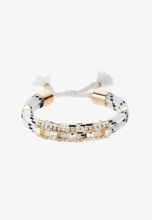 Bracelet tressé blanc et noir avec des accents dorés, comprenant des cristaux clairs dans des montures rectangulaires et des extrémités en forme de pampilles.