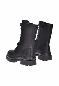 Stivali da combattimento in pelle nera con lacci, suole spesse, cerniere laterali e altezza fino al polpaccio, mostrati da una vista tre quarti posteriore.