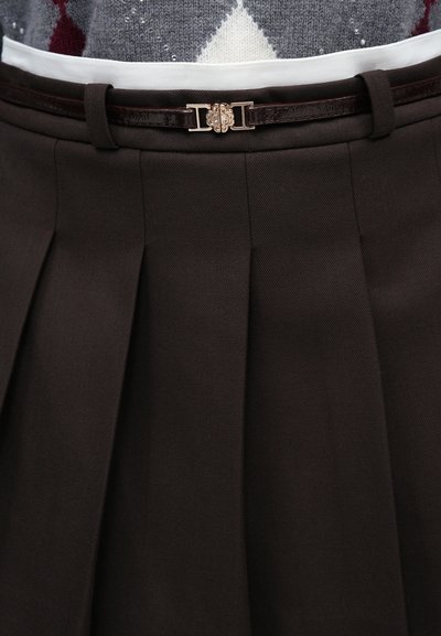 Hnedá plisovaná sukňa z textilného materiálu, s lesklým tmavohnedým opaskom a dekoračnou kovovou sponou v páse.