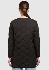 Gequilted zwarte pufferjas met een golfpatroon, lange mouwen en een middellange snit. Glad materiaal met een minimalistische stijl.