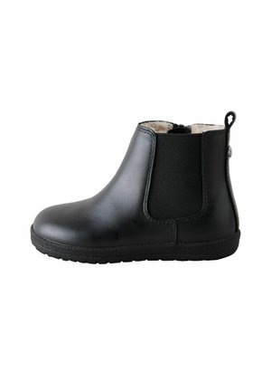 Stivaletto in pelle nera con pannello laterale elastico, anello di tiraggio sul tallone e morbida fodera beige, mostrato dal lato esterno su sfondo bianco.