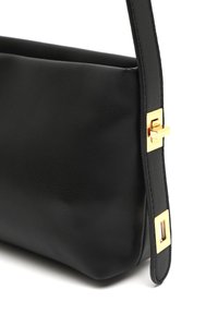 Black leather handbag featuring a smooth texture, a structured shape, and a gold-tone clasp accent on the side.