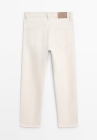 Lyse beige denimbukser med et lige snit, der har to baglommer og et brunt mærke på taljebåndet. Glat tekstur.