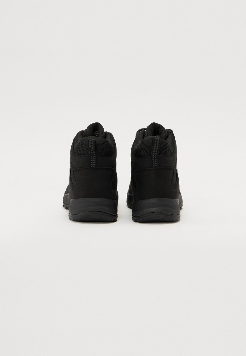 Schwarze Mid-Top-Schuhe mit Obermaterial aus Mesh und synthetischem Material, texturiertem Absatz und Gummisohle. Zwei Ziehschlaufen auf der Rückseite für ein einfaches Anziehen.