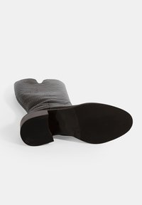 Bruine krokodillen-geprinte leren enkelboot met een spitse neus, gemiddelde hak en gestructureerd oppervlak. Inclusief een gladde, effen zwarte zool.