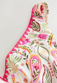 Witte stof met kleurrijke bloemenprint in roze, groen en oranje. Heeft een halslijn met roze rand en decoratieve stiksels.