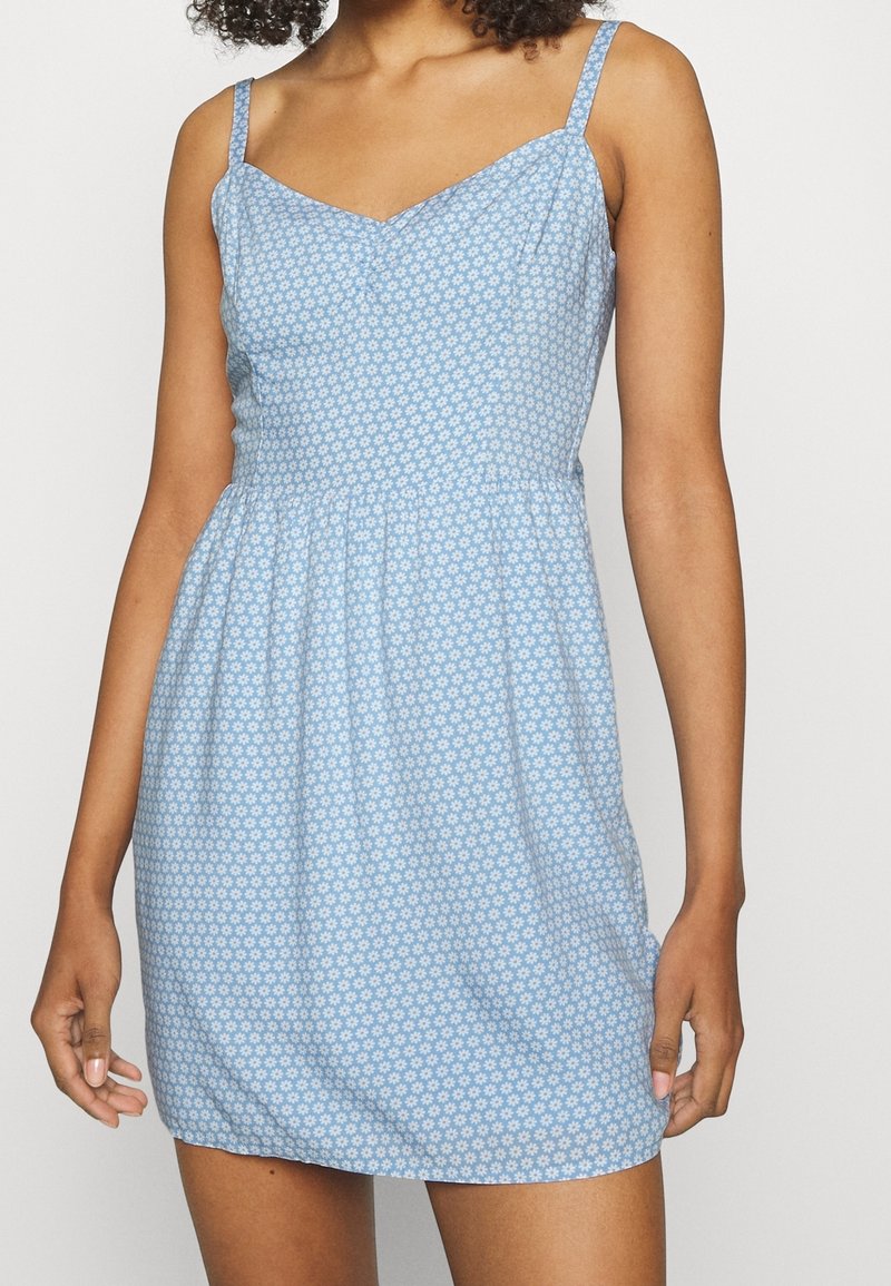 Modré květinové šaty s přiléhavým korzetem, nastavitelné tenké ramínka a rozšířenou sukni. Vyrobeno z lehkého materiálu.