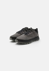 Gray suede and mesh sneakers with black accents, featuring textured surface, thick rubber sole, and round laces in a low-profile design.