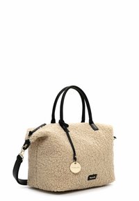 Beige faux shearling handbag with black leather accents and handles, featuring a detachable shoulder strap and a round logo tag.