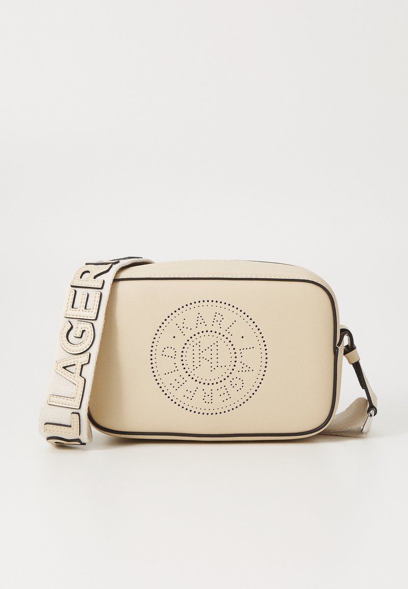 Borsa a tracolla beige realizzata in materiale liscio, con design del logo perforato, forma piatta e una tracolla a contrasto con il testo "LAGERFELD".