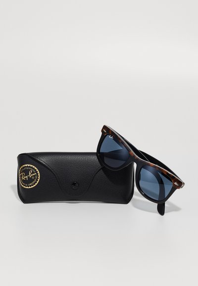Слънчеви очила Ray-Ban Wayfarer с черупка от костенурка и тъмни стъкла, опрени олово на черен кожен калъф Ray-Ban с златен логотип.