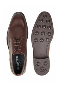 Bruine leren nette schoen met een gladde afwerking, vetersluiting, gevoerde binnenzool en een geruite rubberen zool met cirkelvormige grippen. Maat 42.