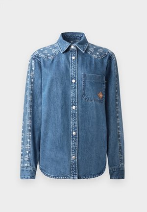 Camisa de mezclilla en azul con botones en la parte delantera, un bolsillo en el pecho y un patrón decorativo en la manga. Presenta botones de presión y un cuello puntiagudo.
