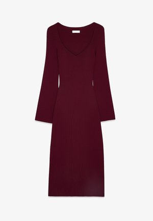 Robe tricotée bordeaux avec un décolleté en V profond, des manches longues évasées et une silhouette ajustée, s'étendant jusqu'au mollet. Texture lisse.