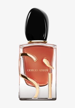 Giorgio Armani Sì doftflaska, med en transparent kvadratisk bas, en bärnstensfärgad vätska, ett svart rundat lock och gulddetaljer på glaset.