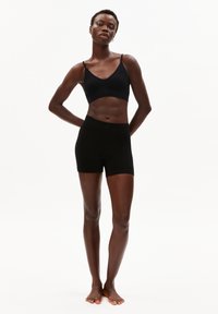 Ensemble soutien-gorge à côtes noir et short taille haute. Tissu doux, coupe ajustée et look minimaliste. Sans logos ni motifs visibles.