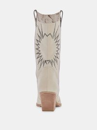 Botín de estilo western en cuero crema con un detalle de serpiente estampado en la parte superior, que cuenta con un tacón de madera apilada y costuras decorativas.