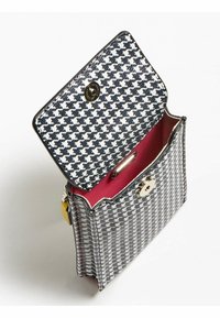 Bolso con patrón de pata de gallo en exterior blanco y negro, herrajes dorados y un interior vibrante rosa, con cierre de broche.