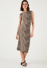 Leopard print, sleeveless midi dress with a fitted bodice, smooth texture, and a slight drape at the shoulder. Black strappy sandals.