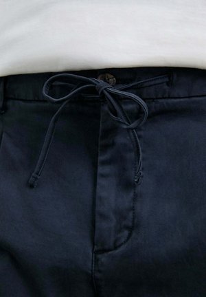 Pantalones azul marino con un acabado texturizado, que presentan un cordón de ajuste en forma de lazo y un cierre de botón en la cintura.