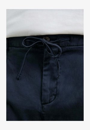 Pantalones azul marino con un acabado texturizado, que presentan un cordón de ajuste en forma de lazo y un cierre de botón en la cintura.