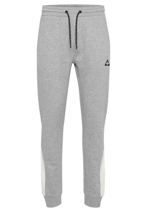 Pelēki sporta bikses ar melnu auklu, elastīgu jostasvietu, baltām sānu daļām un nelielu melnu logotipu priekšā. Mīksts kokvilnas auduma maisījums.