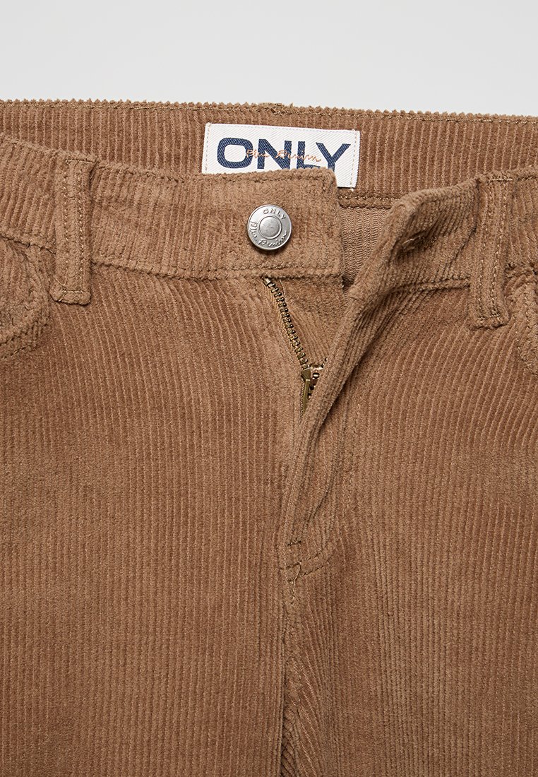 Pantaloni in corduroy marrone con zip e chiusura a bottone metallico, con texture a righe verticali e etichetta 'ONLY' in vita.
