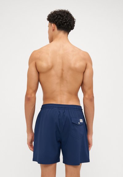 Shorts de bain bleu marine avec une taille élastique, une poche arrière avec fermeture à bouton et un tissu lisse et léger.