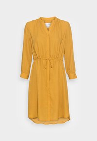 Vestido amarillo con mangas largas, cintura ajustable, cuello y botones delanteros. Presenta un sutil patrón de lunares blancos y un dobladillo curvado.