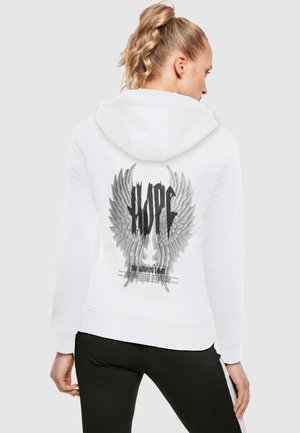Felpa bianca con un grafiche di ali d'angelo e la parola "SPERANZA" in nero sul retro. Presenta un cappuccio con cordino e polsini a costine.