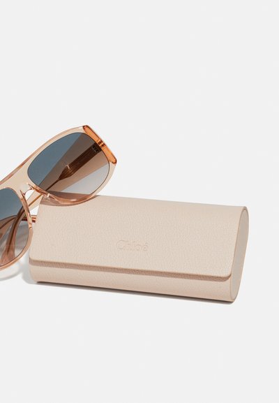 Ochelari de soare Chloé cu lentile de culoare maron închis și un capac texturat de un bej deschis, având un design minimalist și un logo embosat.